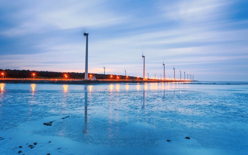 Wind turbines at dusk by the sea
