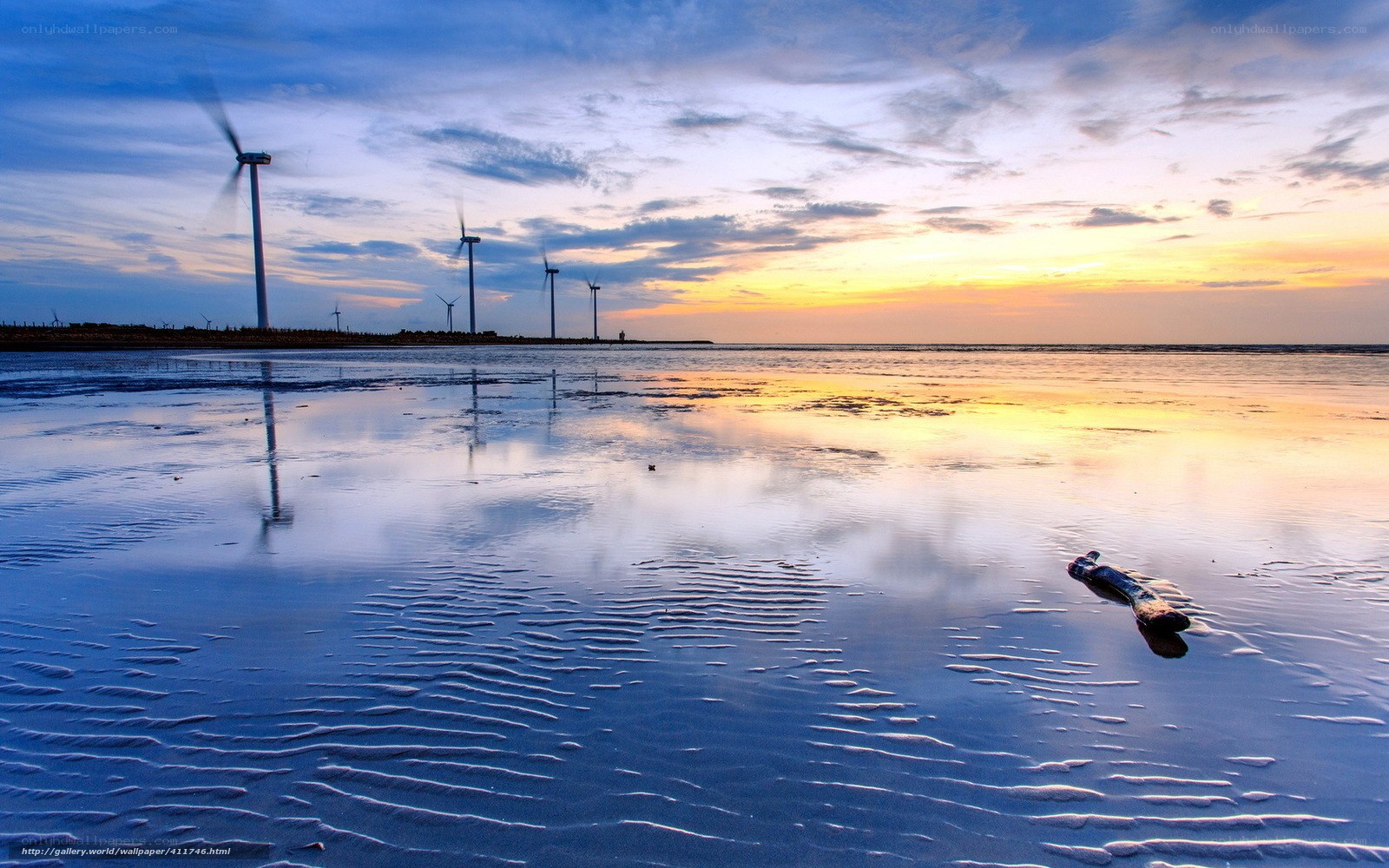 Wind turbines at sunset on a beach