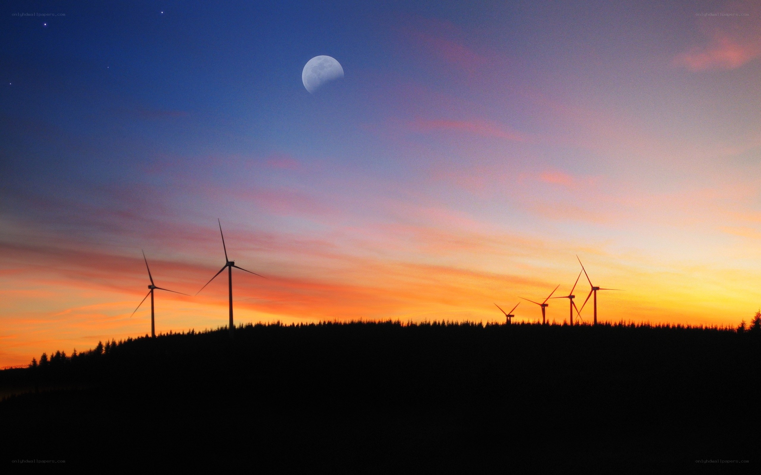 Wind turbines at sunset with moon