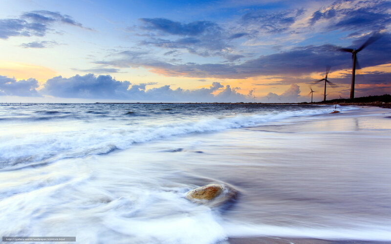 Wind turbines on a beach at sunset