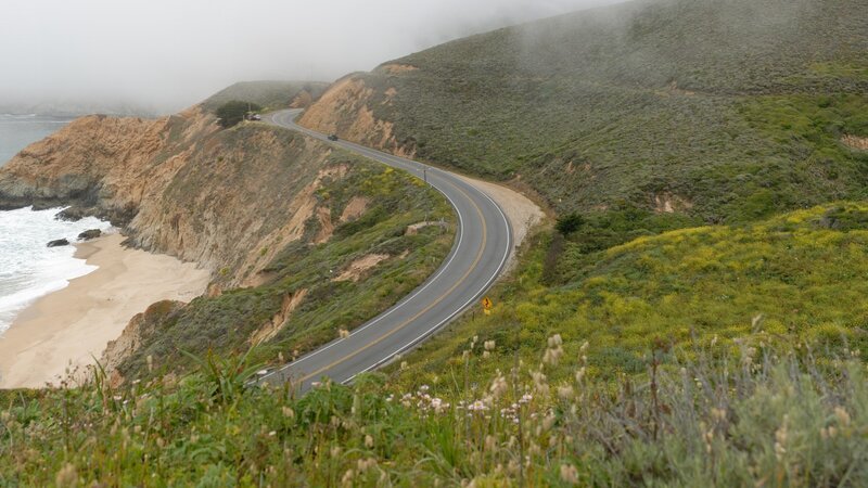 winding coastal road in fog