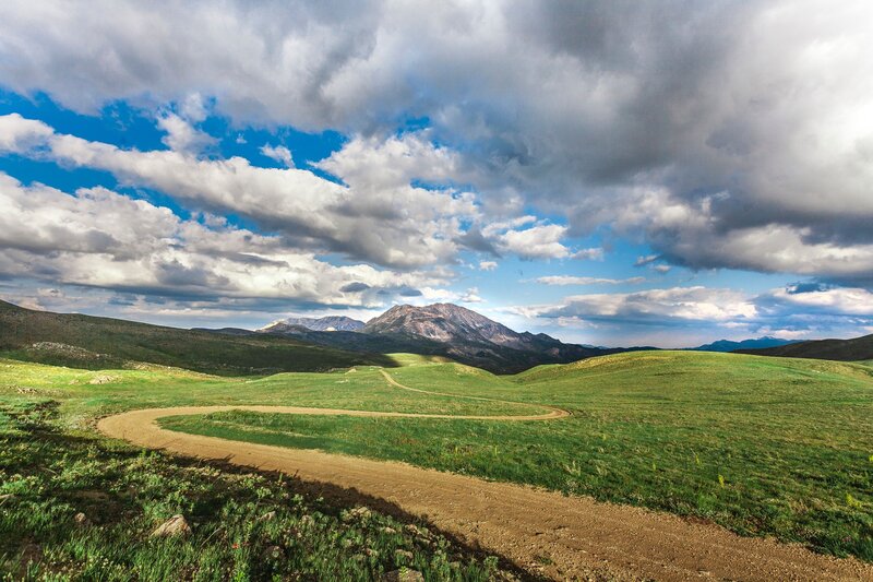 Winding dirt road through green hills