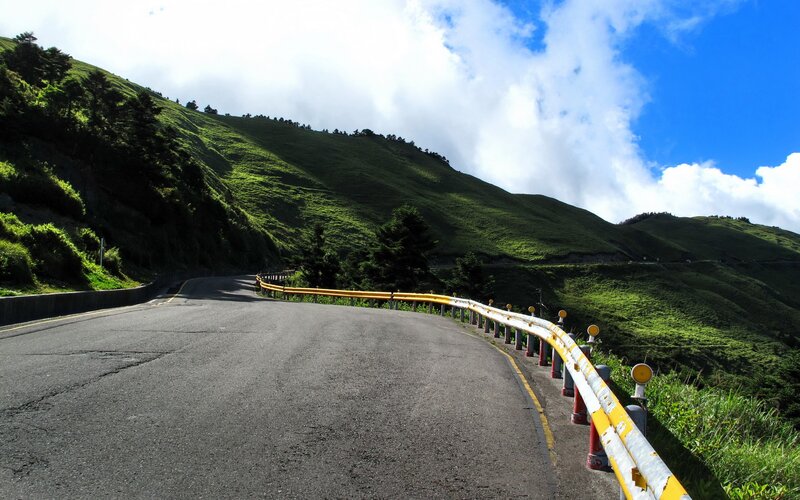 Winding mountain road with green hills