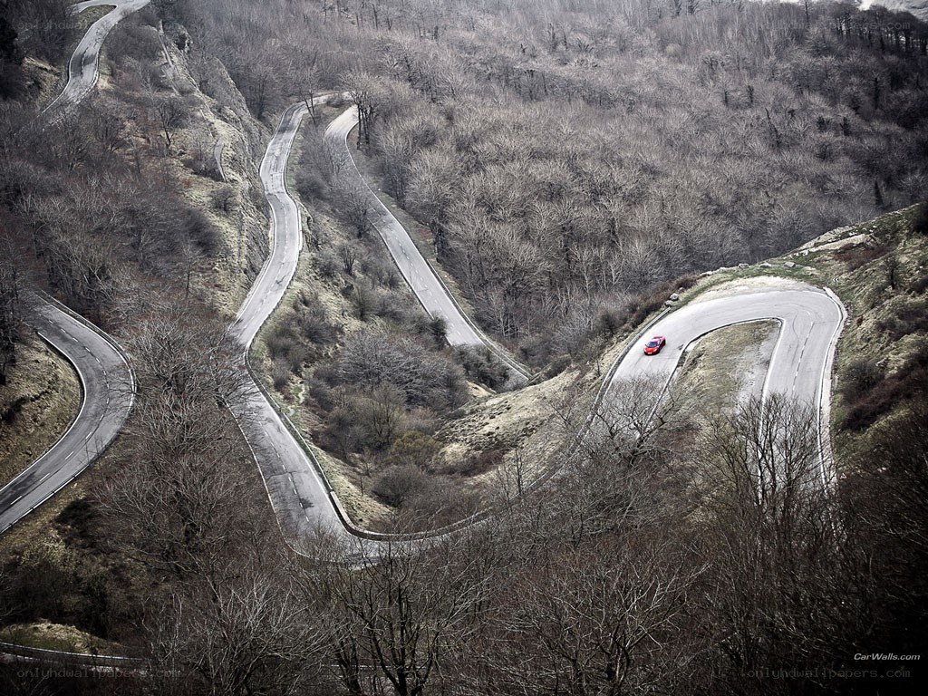 Winding mountain road with red car
