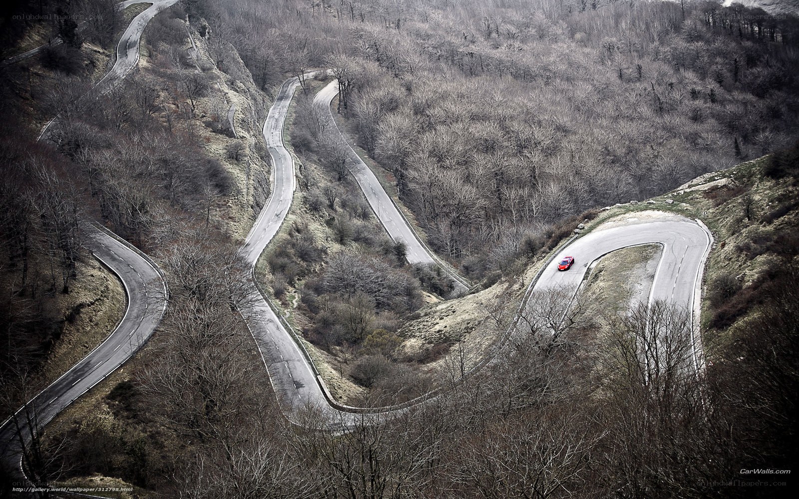 winding mountain road with red car