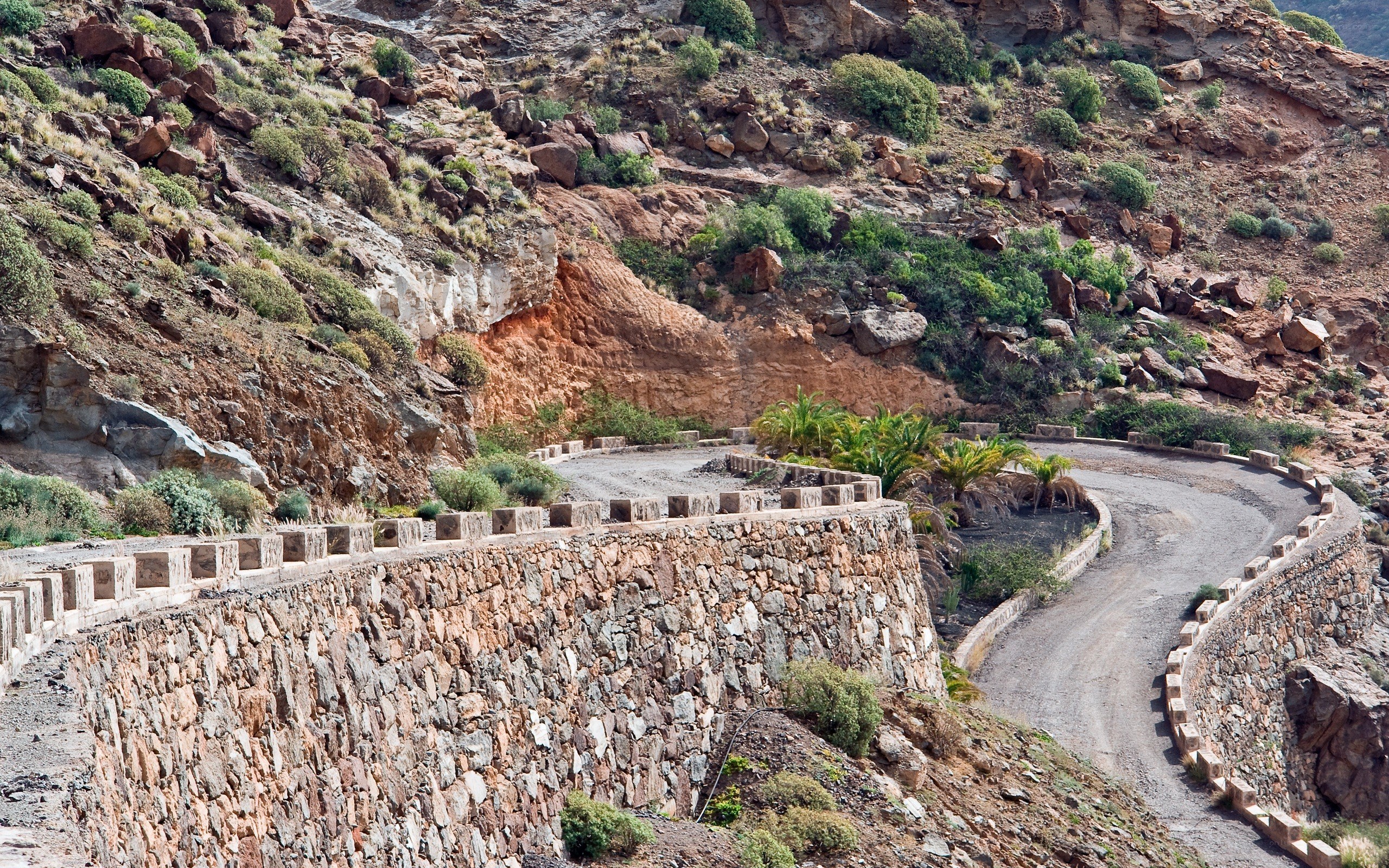 Winding mountain road with stone wall