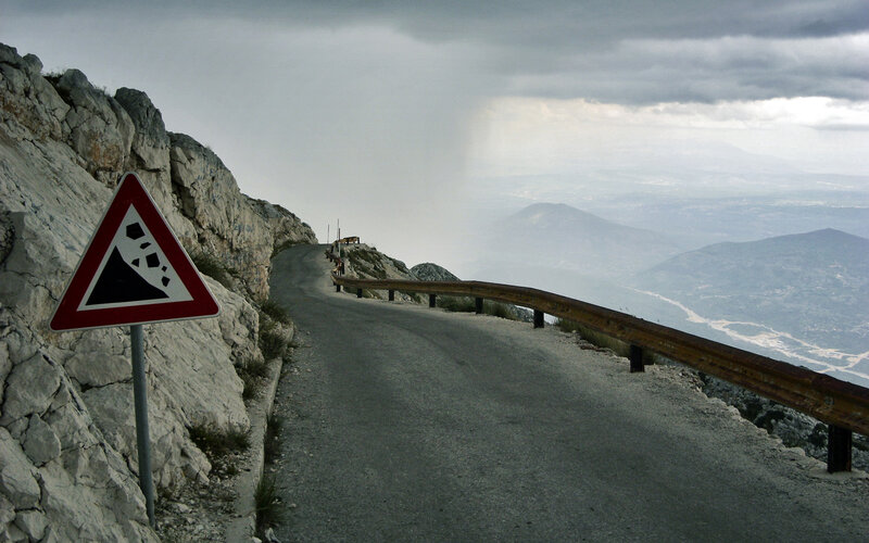 Winding mountain road with warning sign