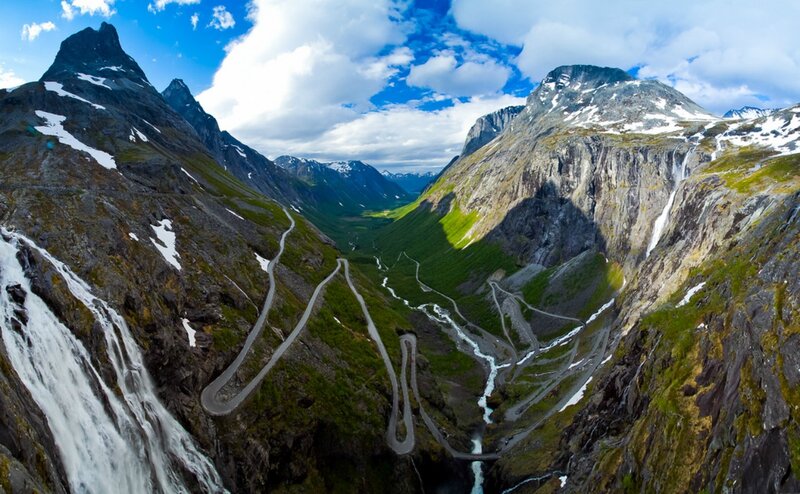 winding mountain road with waterfalls