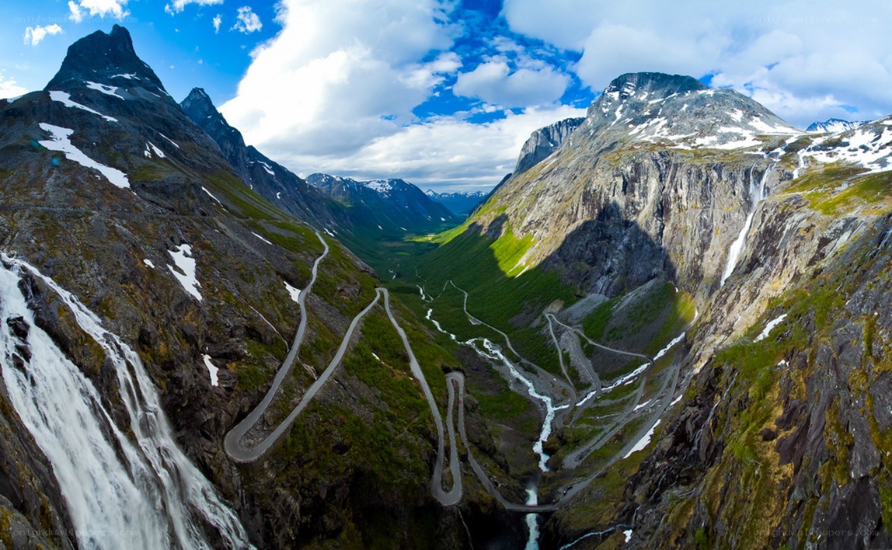 winding mountain road with waterfalls