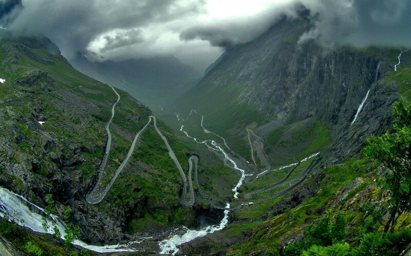 winding mountain road with waterfalls