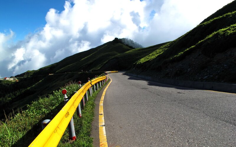 Winding mountain road with yellow guardrail