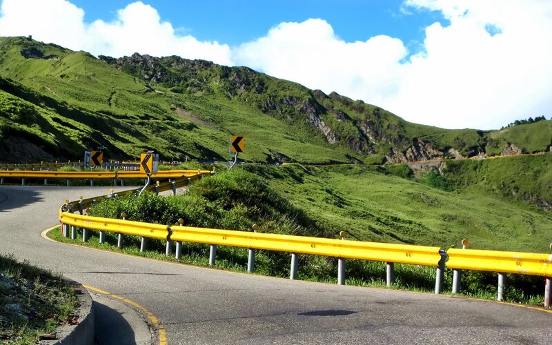 Winding mountain road with yellow guardrails