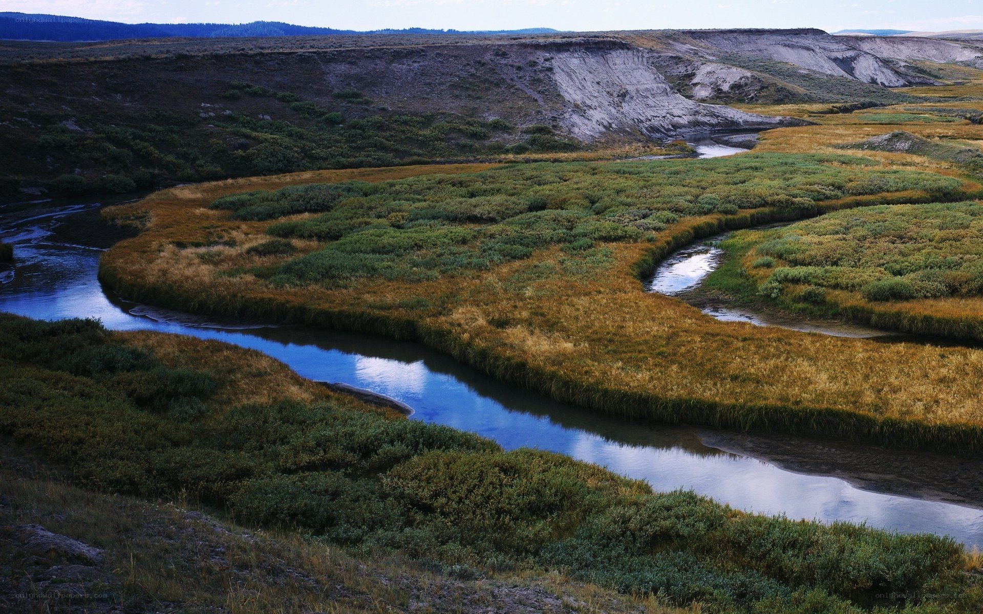 Winding river through grassy valley