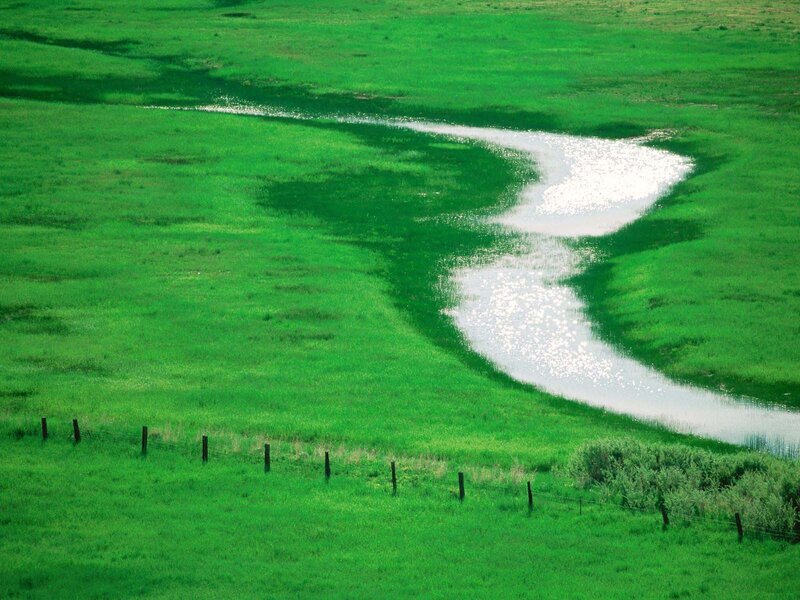Winding river through green fields