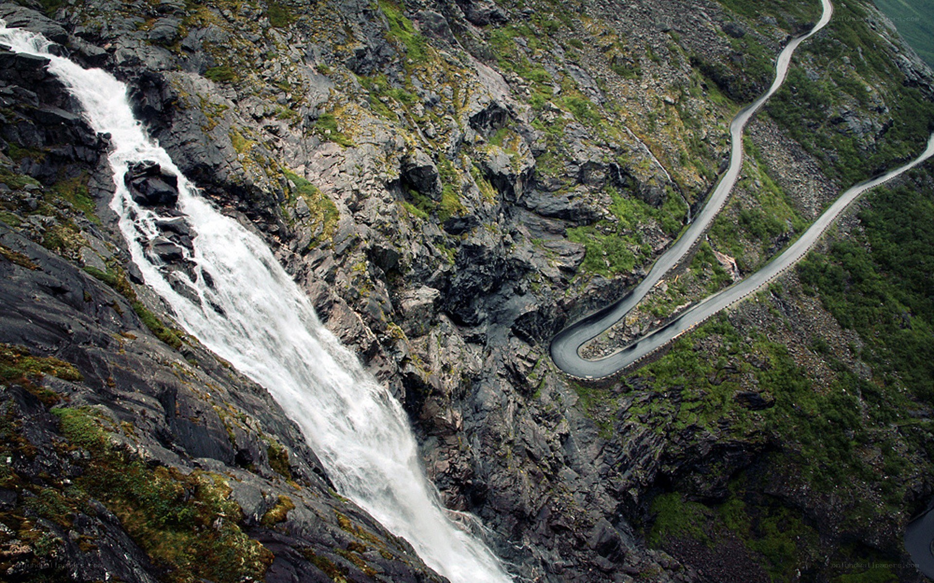 Winding road beside a waterfall