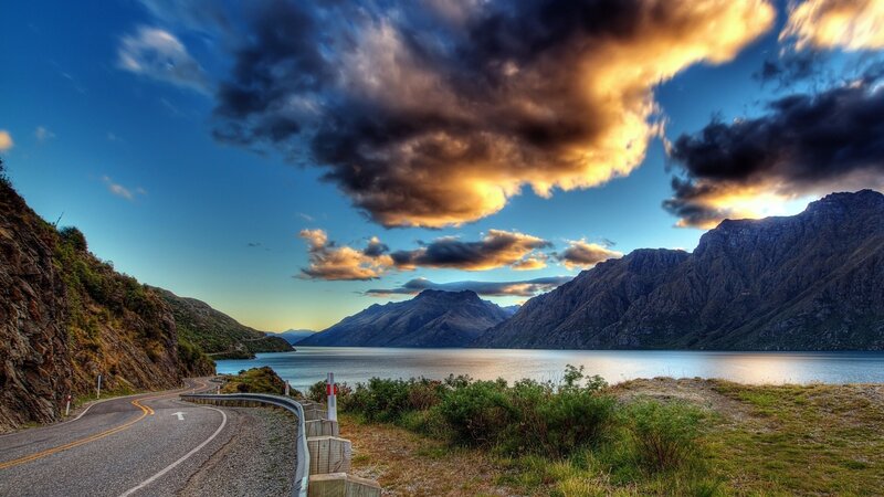 Winding road by a lake at sunset