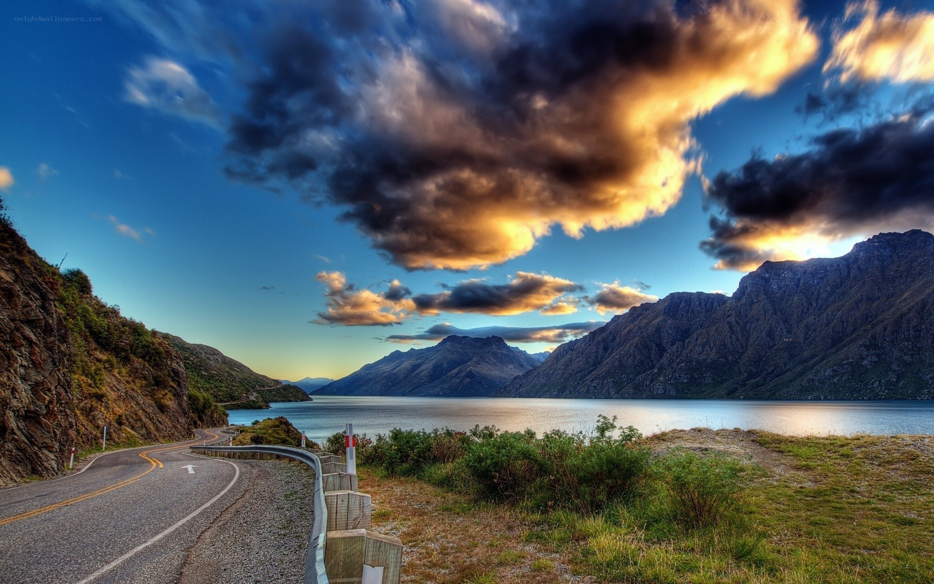Winding road by a lake at sunset