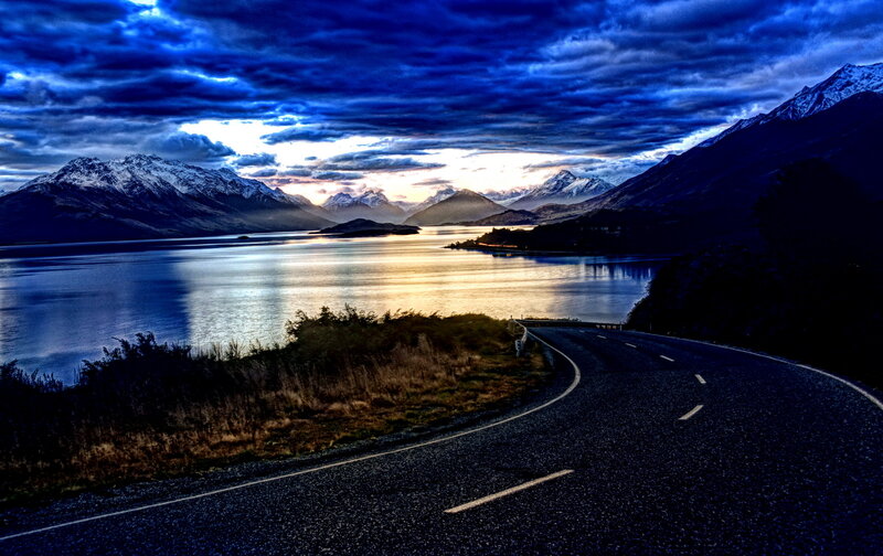 Winding Road by Lake — Blue, Dramatic, Sunset, Photograph, Mountains