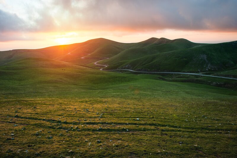 Winding Road in Hills — Green, Serene, Sunset, Photograph, Sun
