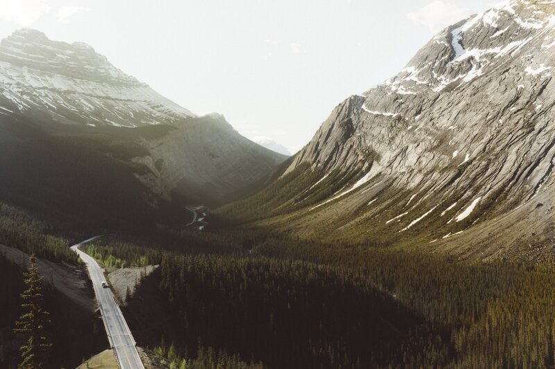 Winding Road in Mountain Valley — Green, Serene, Afternoon, Photograph, Mountains