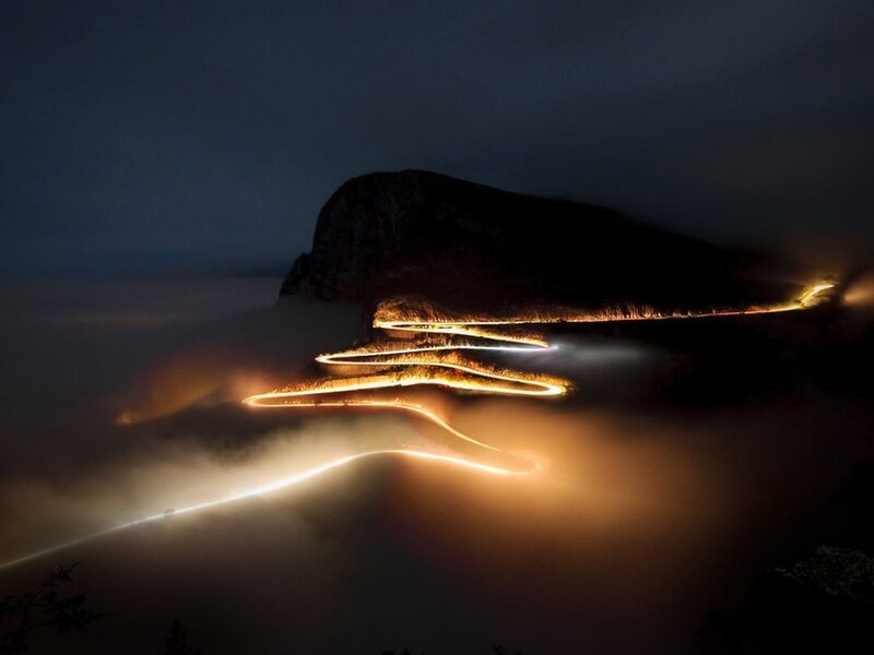 Winding road through clouds at night
