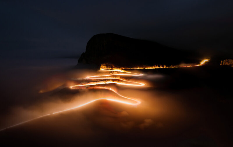 Winding road through fog at night