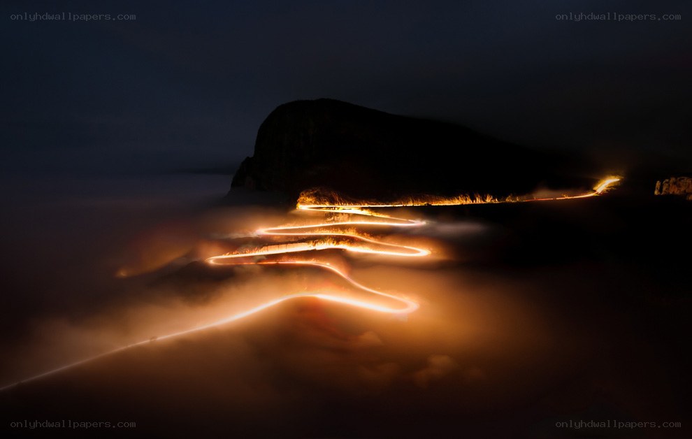 Winding road through fog at night