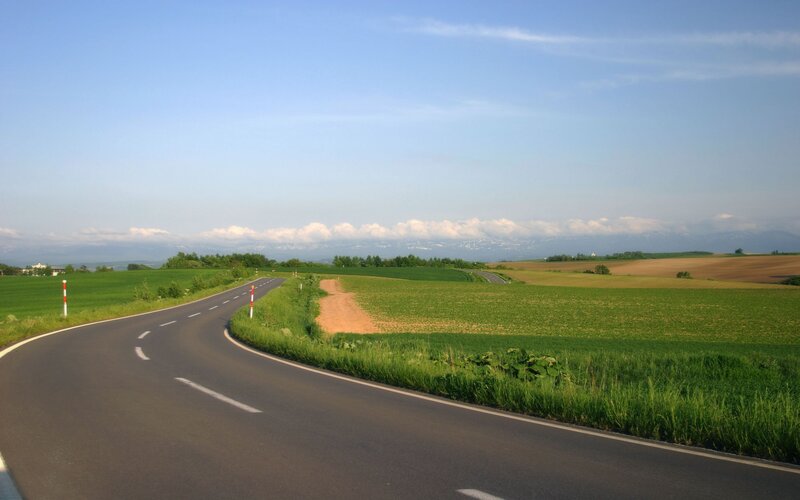 Winding road through green fields