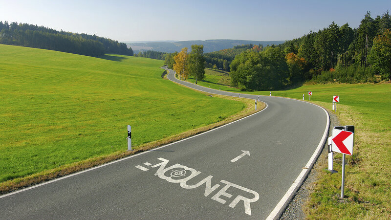 Winding road through green hills