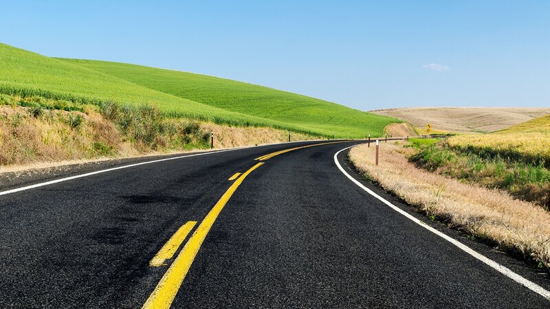 Winding road through green hills