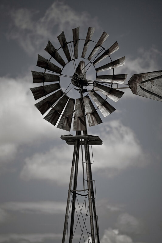 Windmill against cloudy sky