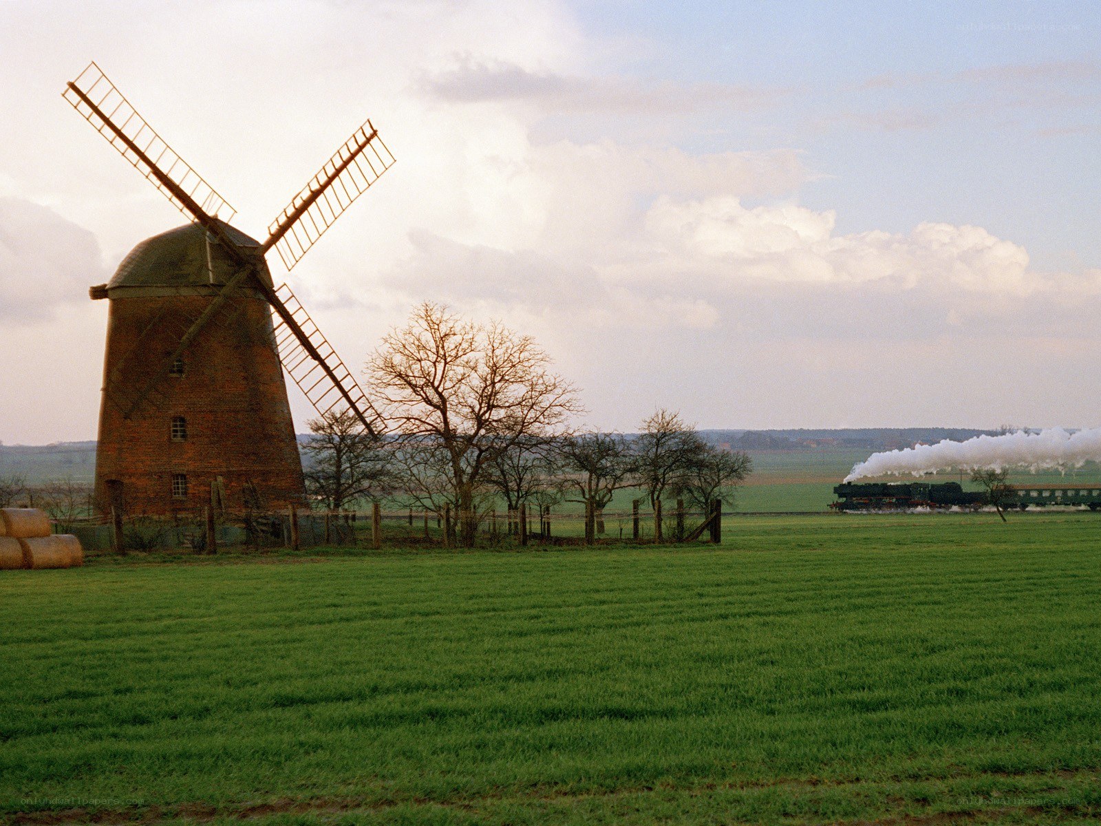 Windmill and steam train in a field