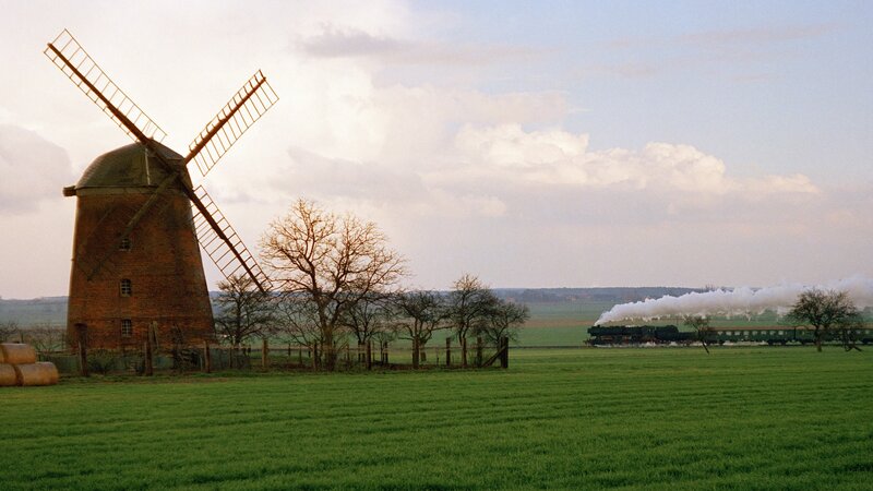 Windmill and steam train in countryside