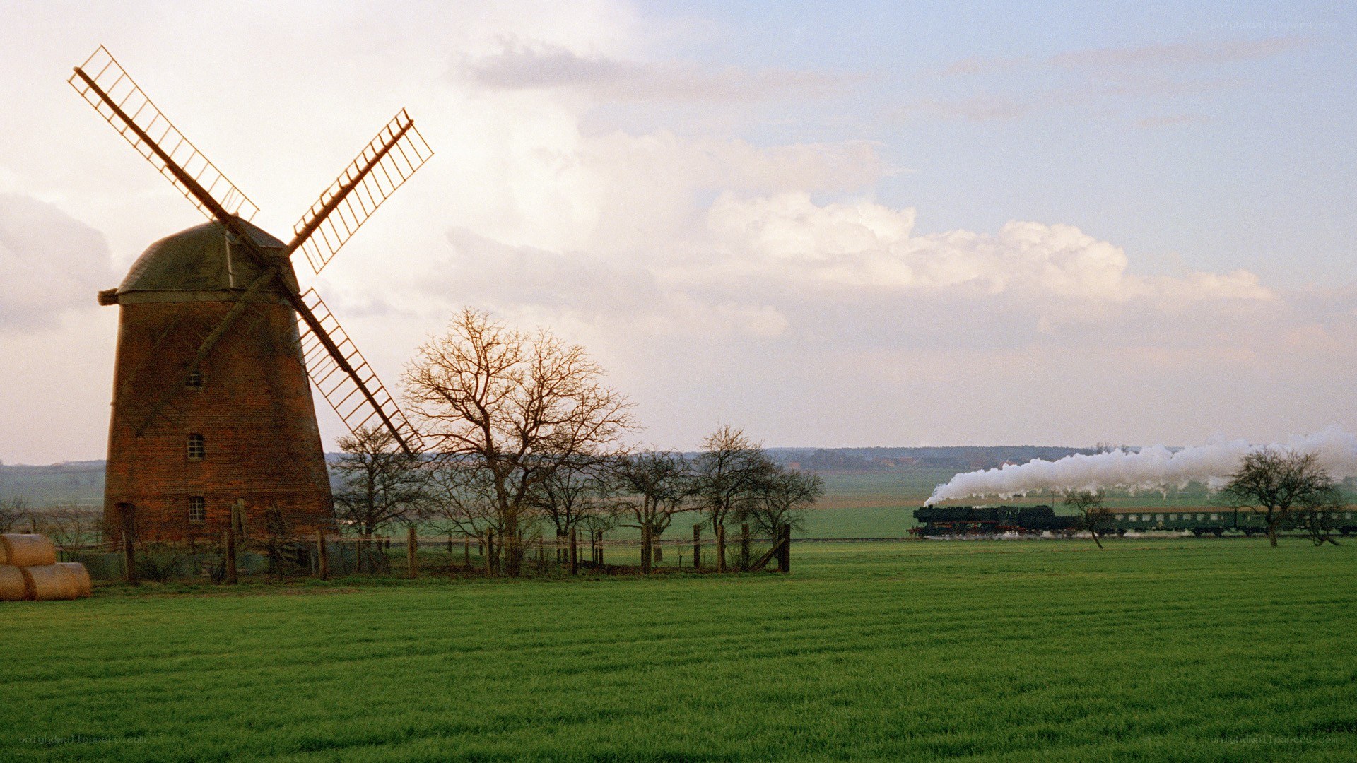 Windmill and steam train in countryside