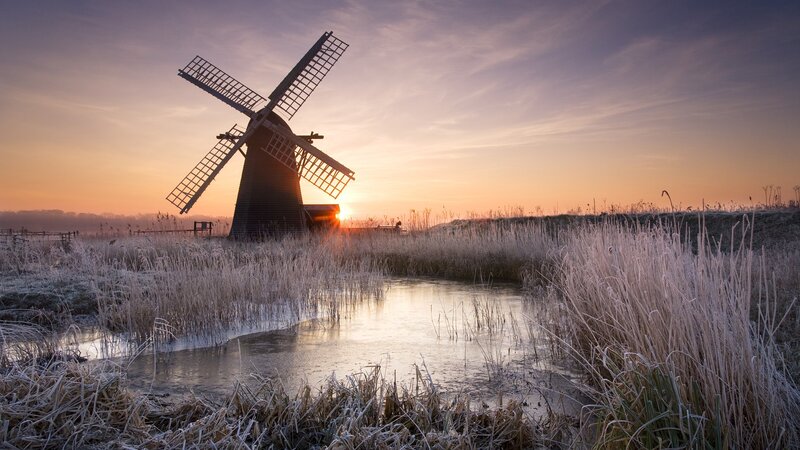 Windmill at sunrise in frosty landscape