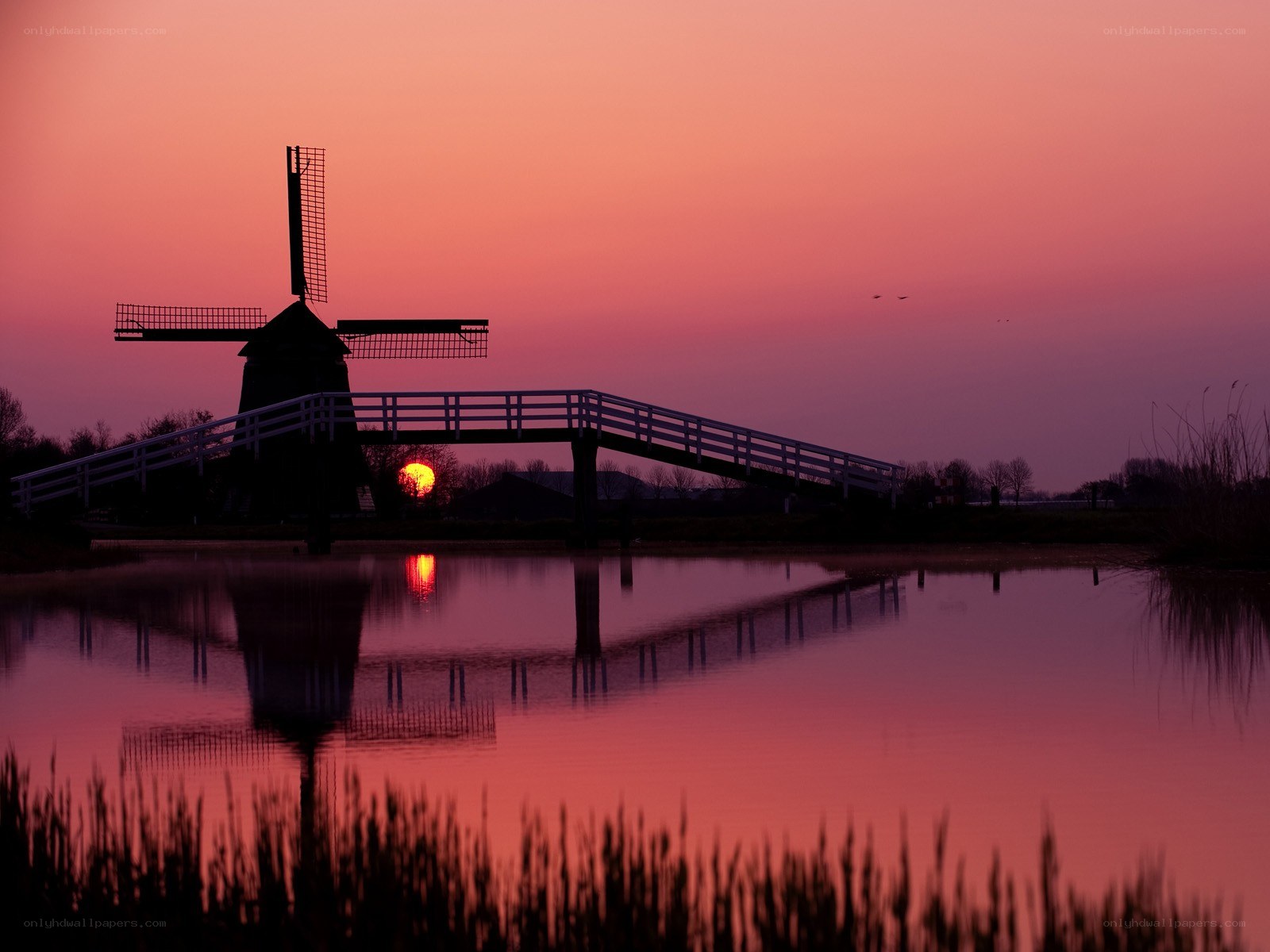 Windmill at sunset over a canal