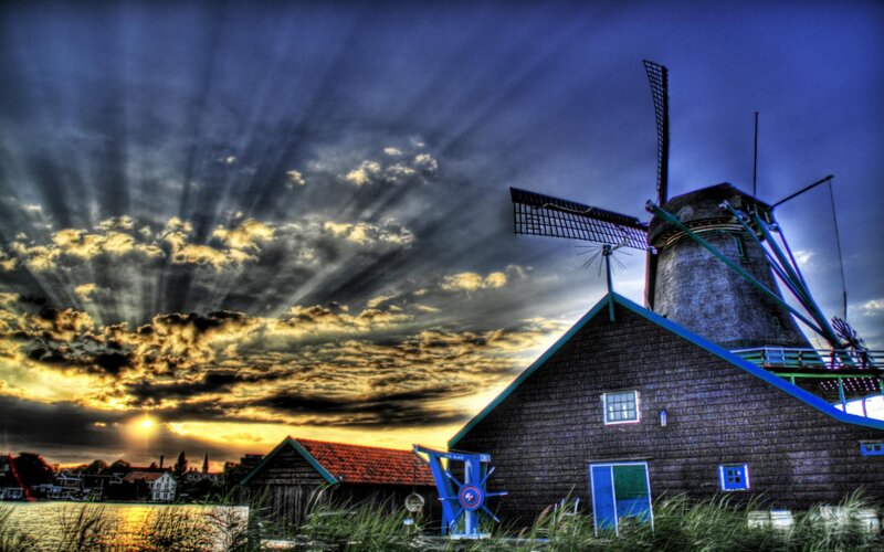 Windmill at sunset with sunbeams