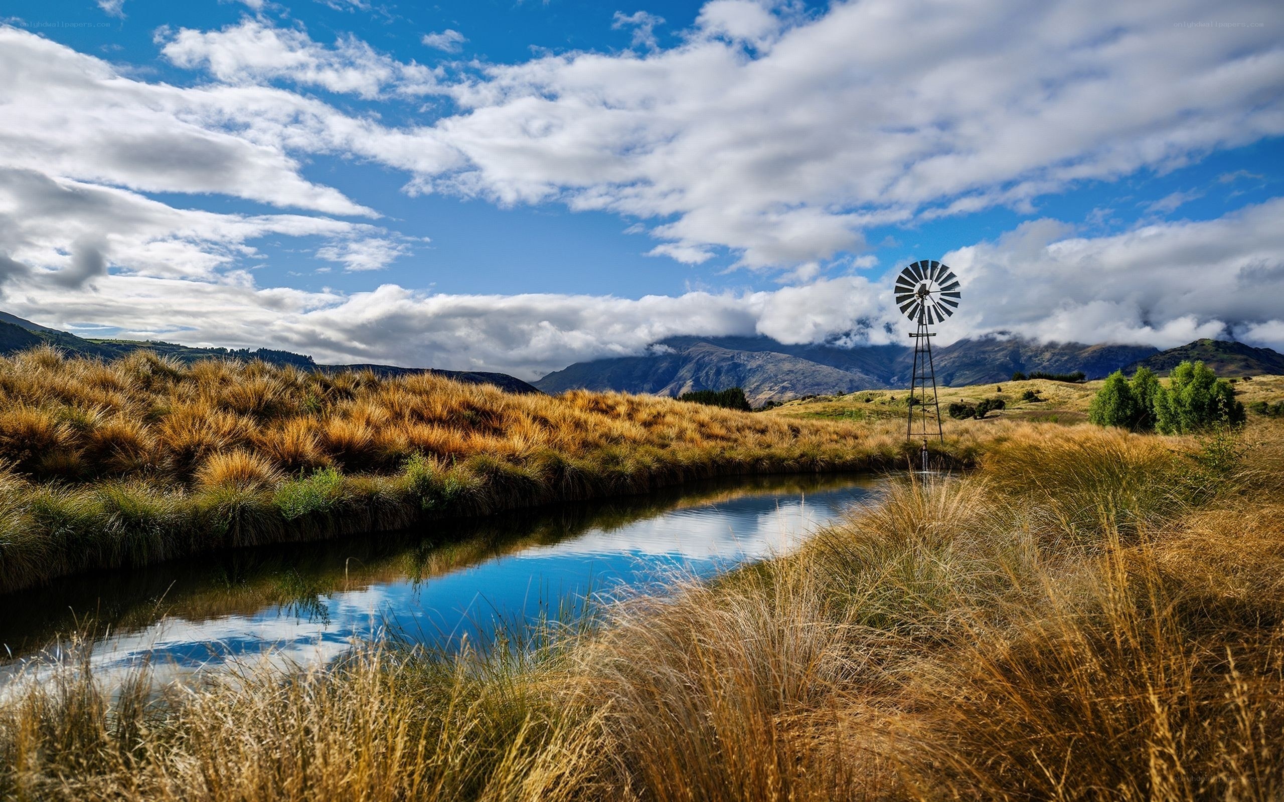 Windmill by a river in the countryside