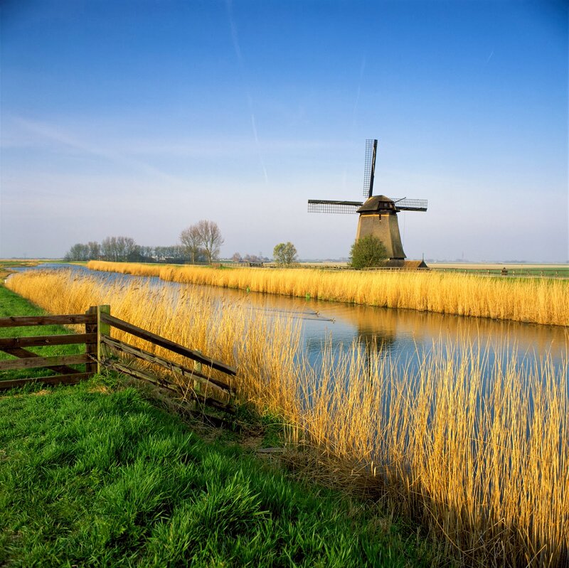 Windmill by Canal — Blue, Serene, Afternoon, Photograph, Reeds, Fence