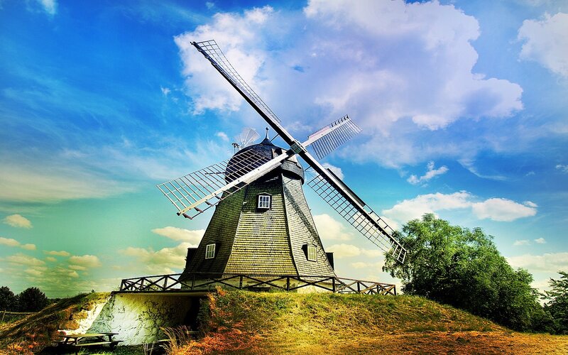 Windmill on a hill under blue sky
