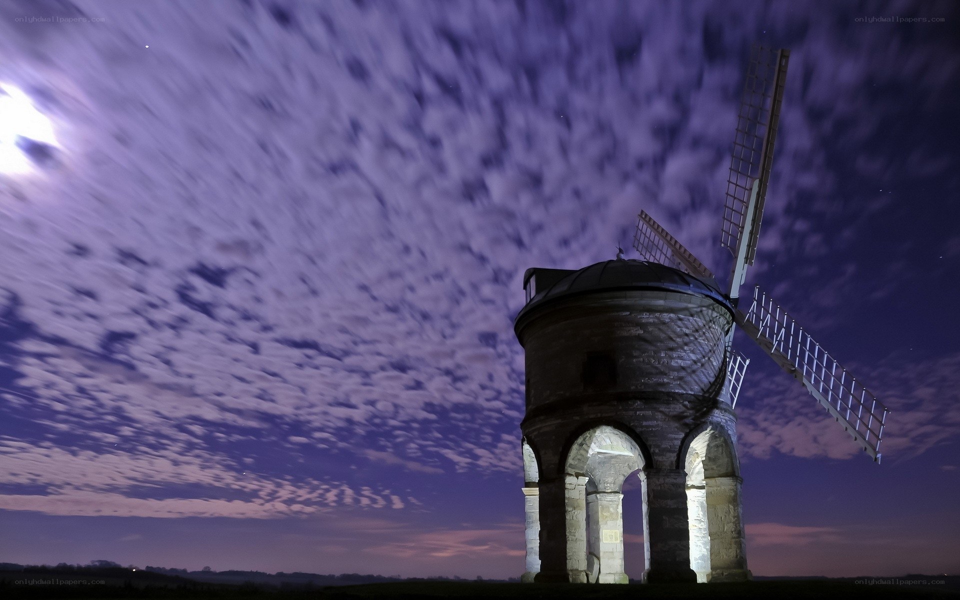 Windmill under moonlit sky