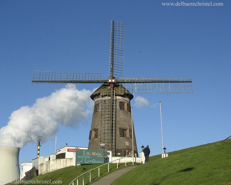 Windmill with smokestack in background