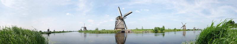 Windmills Along a Canal — Blue, Serene, Afternoon, Photograph, Grass