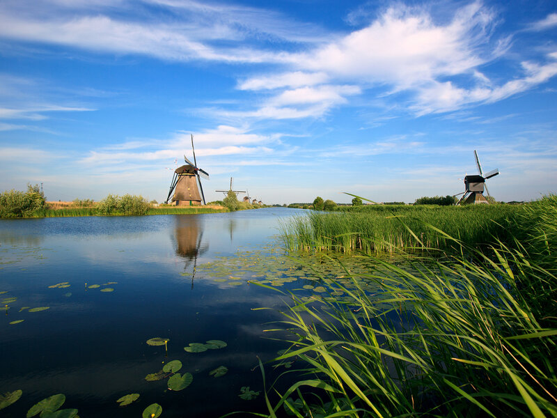 Windmills Along a Canal — Blue, Serene, Afternoon
