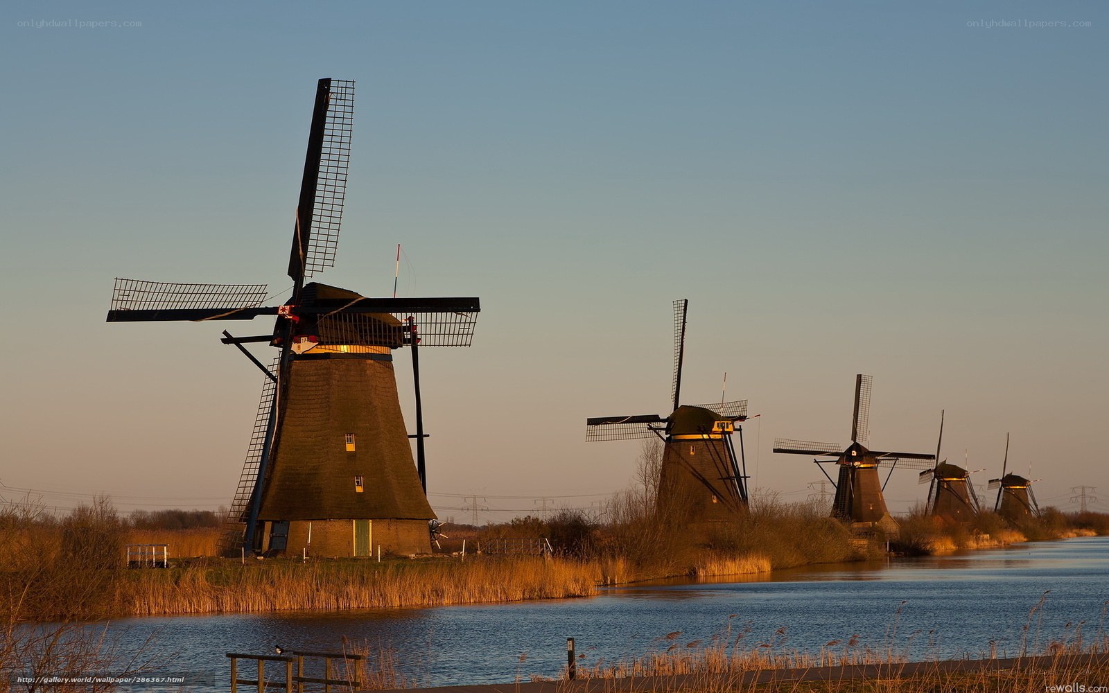 Windmills by a canal at sunset