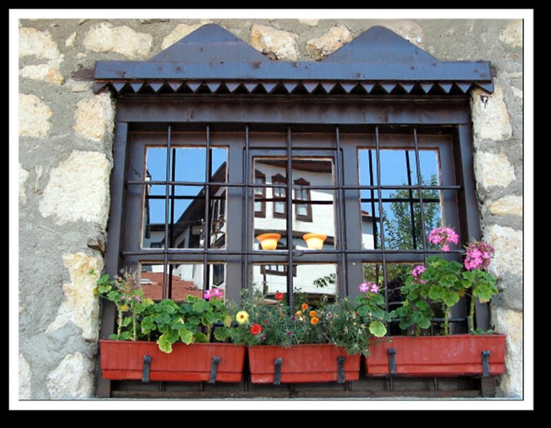 window with flowers in stone wall