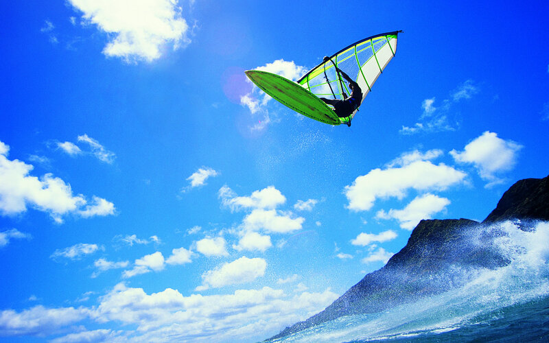 Windsurfer soaring above waves