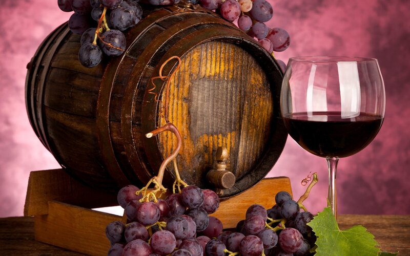 wine barrel with grapes and glass