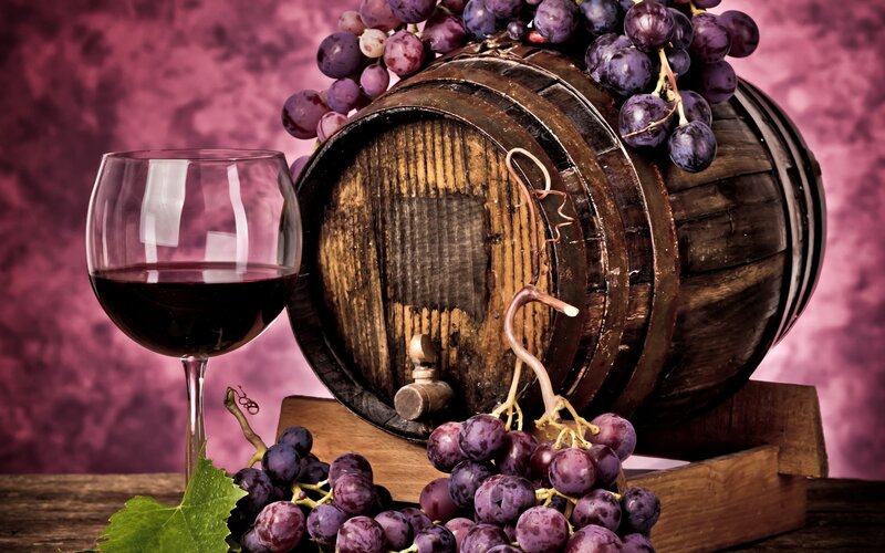 wine barrel with grapes and glass