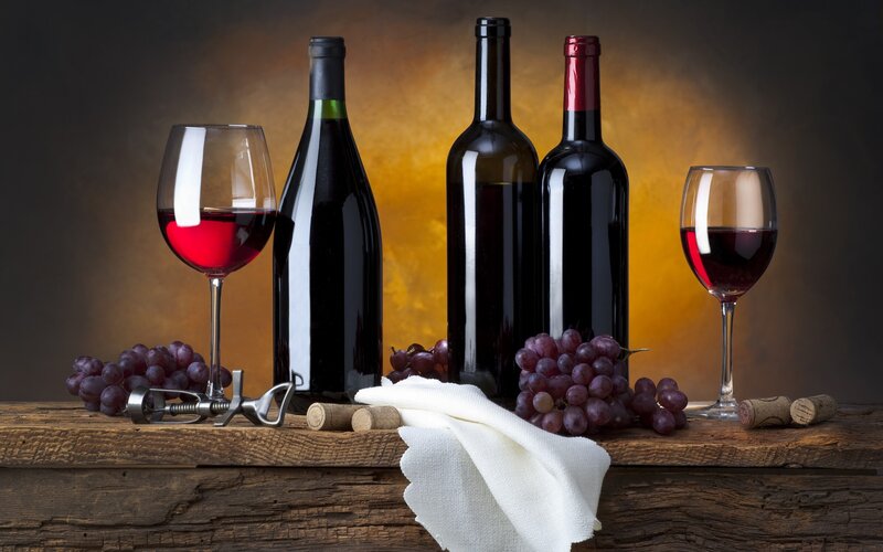 Wine bottles and grapes on wood